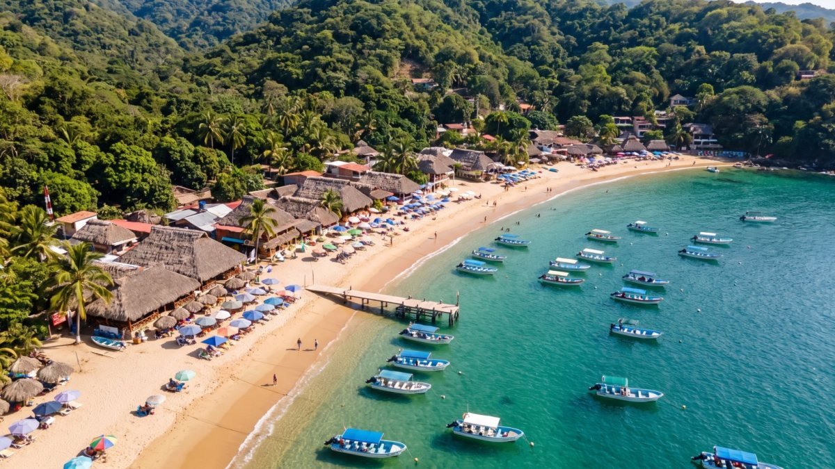 Aerial view of Las Ánimas beach with palapa restaurants and boats anchored in turquoise water, Puerto Vallarta south shore