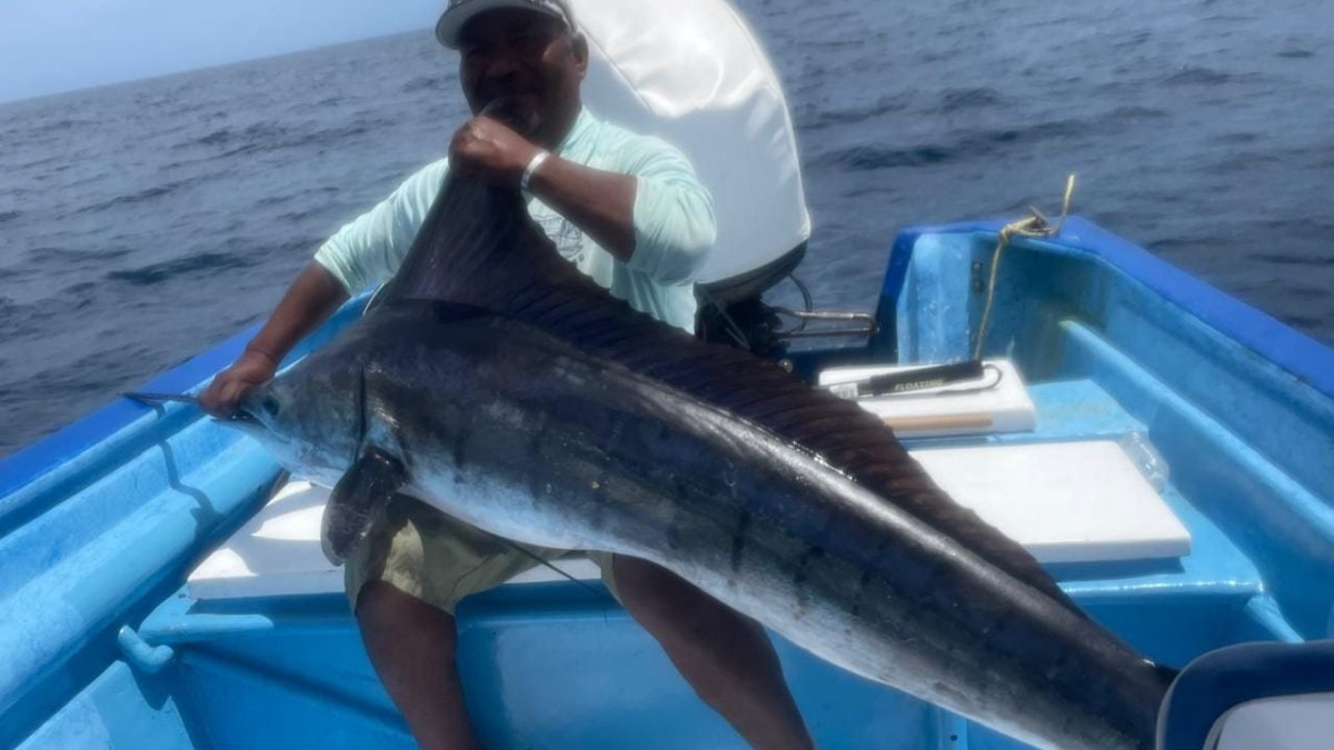 Loreto Star captain holding a billfish aboard the panga on an offshore fishing charter in Loreto