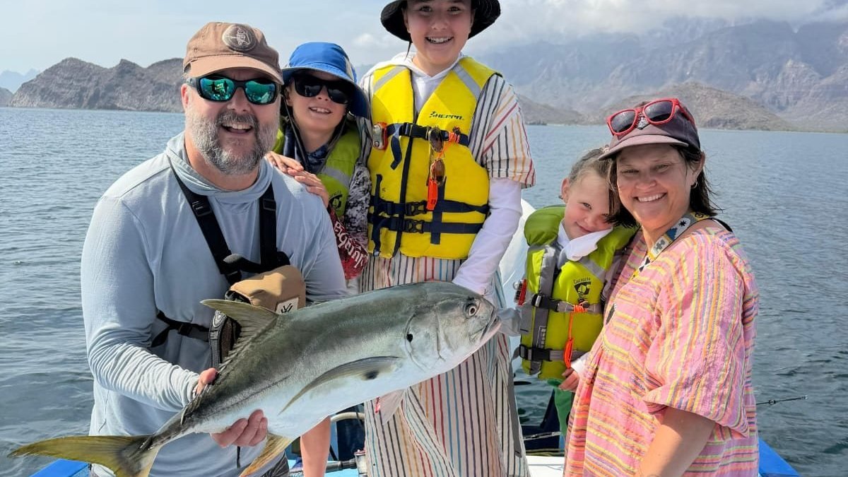 Family holding a yellowtail caught on a fishing charter in Loreto aboard the Loreto Star panga