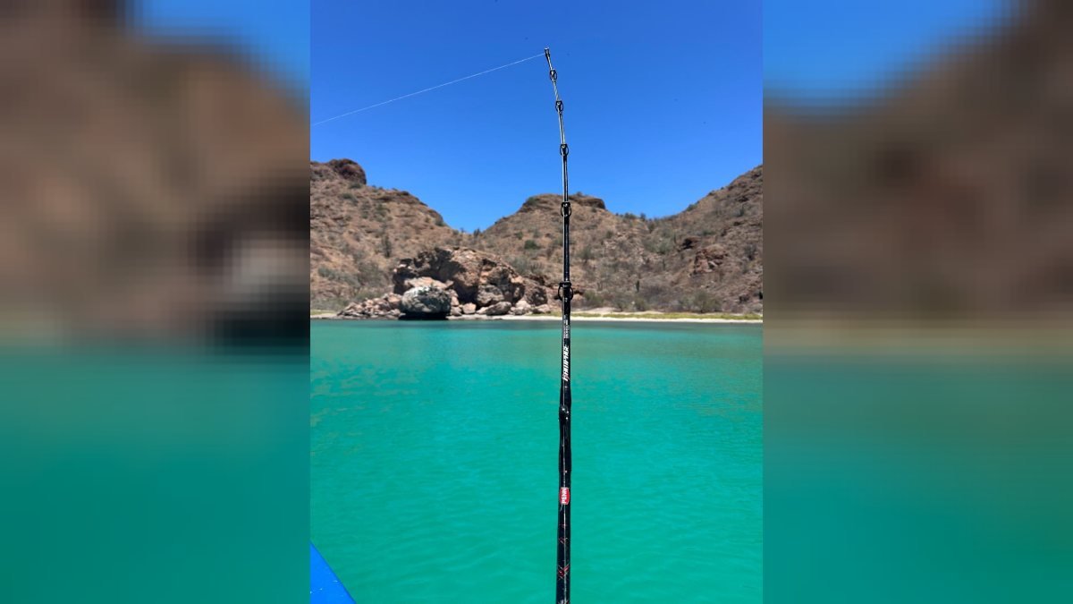 Fishing rod set on the bow of the Loreto Star panga in a turquoise cove of the Loreto Bay National Marine Park