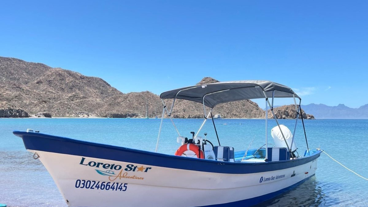 The Loreto Star shaded panga beached on the white sand of Isla Coronado, Loreto Bay National Marine Park